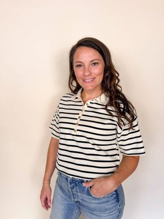 Ivory and black striped short sleeve knit polo featuring a classic collar and pearl-inspired button placket.
