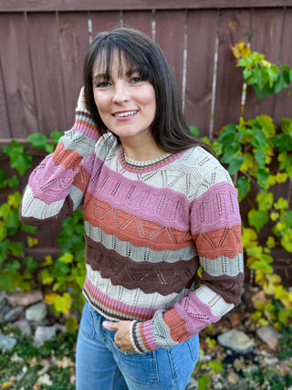 Woman wearing a colorful wavy patterned sweater outdoors 