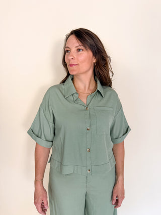 Woman wearing a green outfit against a plain background