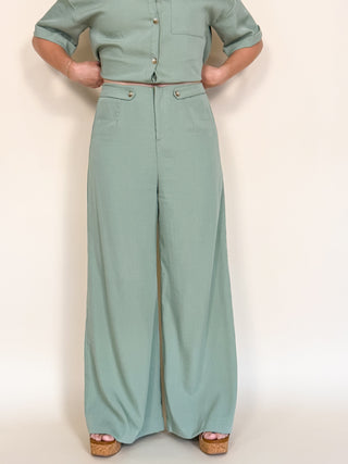 Person wearing a light green set on a plain background