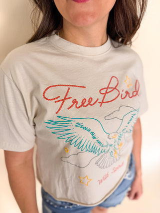 Person wearing a t-shirt with 'Free Bird' design and text.