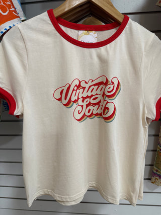 Cream ringer tee with “Vintage Soul” retro graphic and bold red collar and sleeve trim, hanging in boutique 
