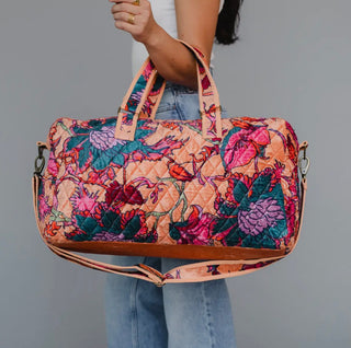 Quilted floral weekender duffel bag with multicolor print and removable shoulder strap.