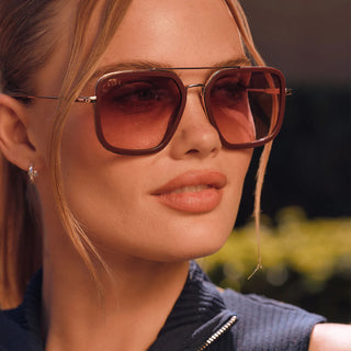 Close-up of a woman wearing sunglasses with a blurred natural background